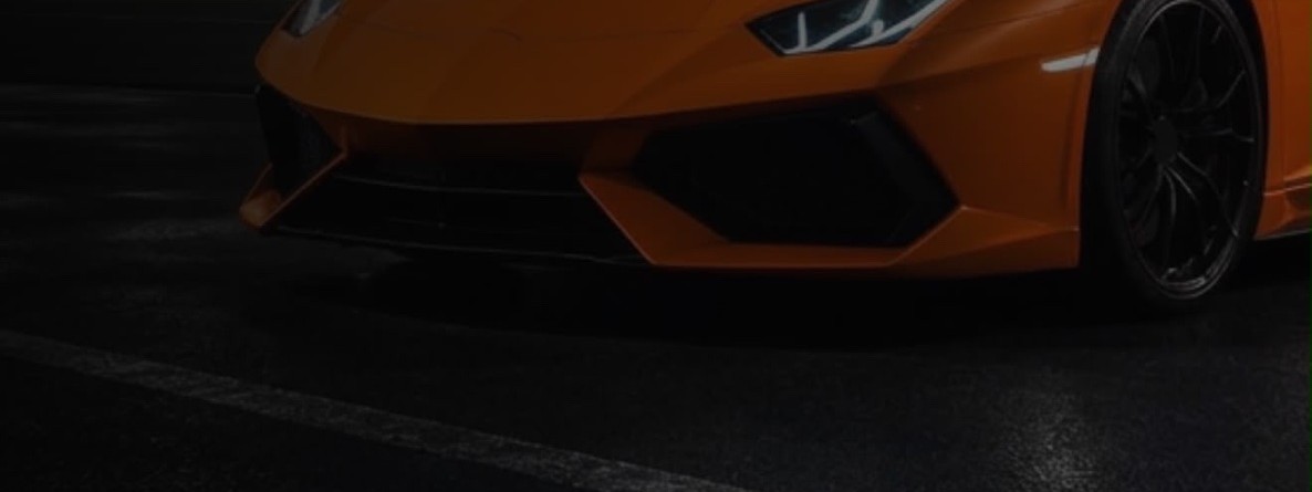 Orange supercar on a wet track at night